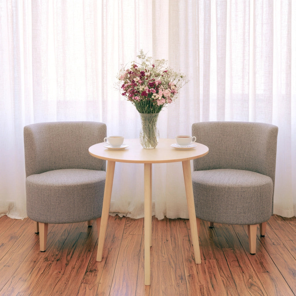 Light brown round wooden side table by Zenoakstudio in a cozy living room seating area.