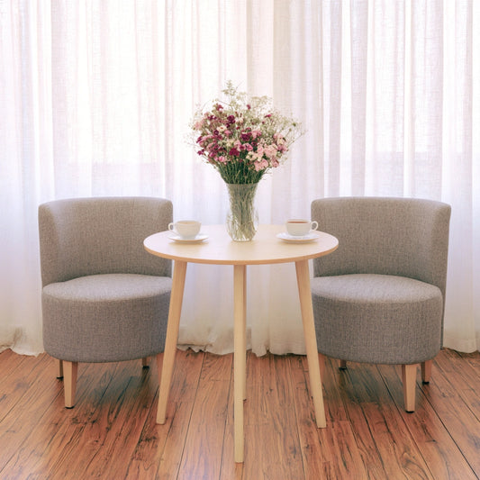 Light brown round wooden side table by Zenoakstudio in a cozy living room seating area.